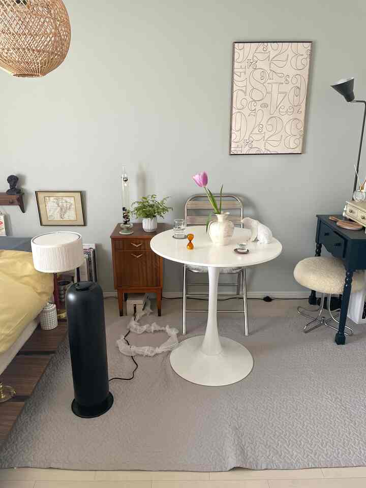 ナチュラルカラーの寝室とダイニングテーブルが調和したシンプルで落ち着いた雰囲気のインテリア