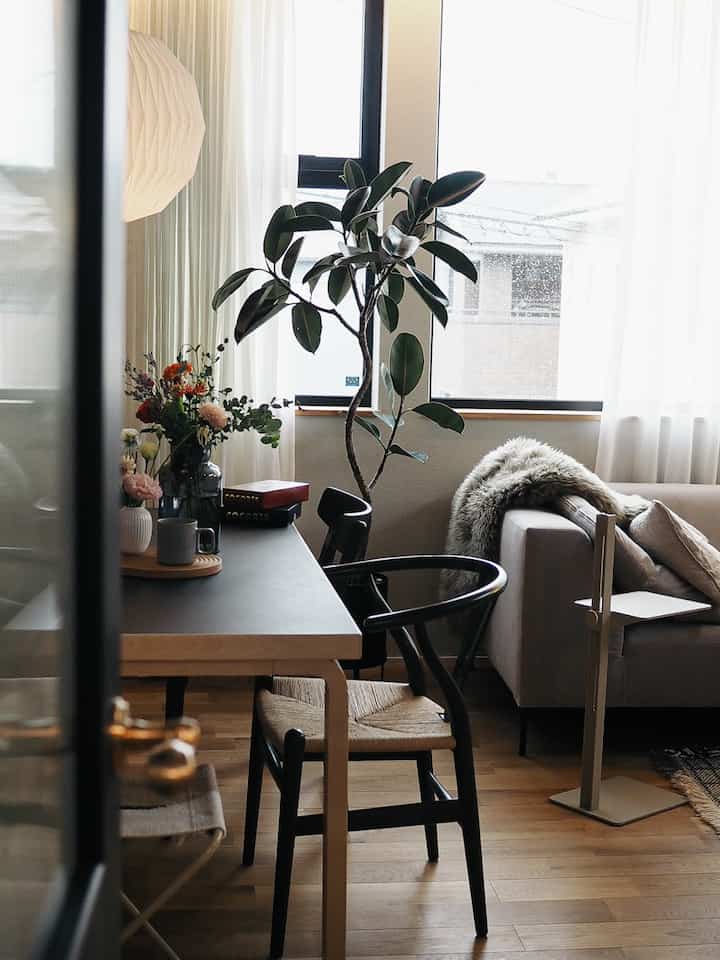 ナチュラルな色調のリビング兼ダイニングルーム、Carl Hansen & SonのCH24チェアと自然光が差し込む居心地の良いインテリア