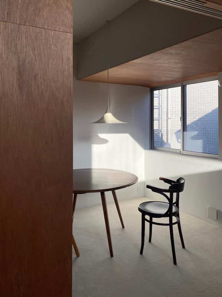 ナチュラルカラーのダイニングルーム、丸テーブルとヴィンテージブラックチェアが配置された落ち着いた雰囲気の空間