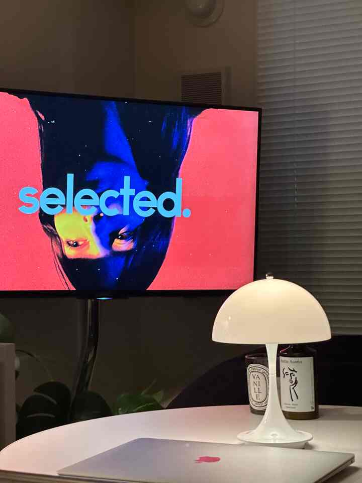 温かみのあるホワイトトーンのリビング、テレビとテーブルランプが配置された落ち着いた雰囲気のインテリア