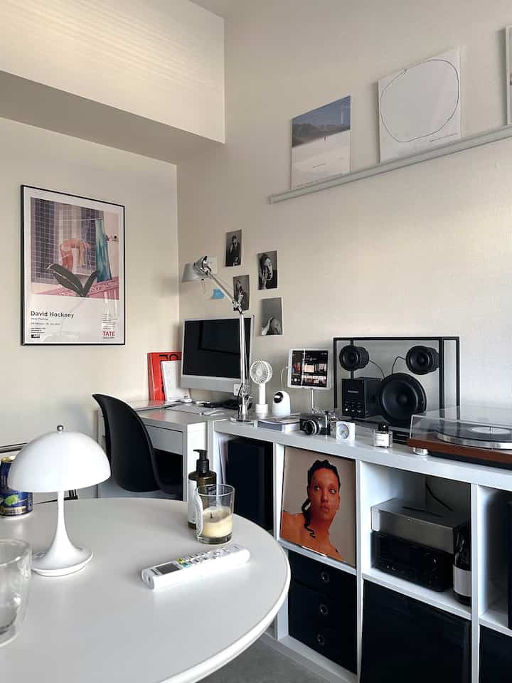 ホワイトトーンの小さな部屋、デスクトップPCとターンテーブルが配置された整ったホームオフィス空間