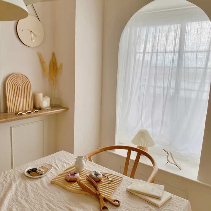 白と木目調が調和するリビング風のおうちカフェ空間、自然素材の小物と柔らかな光が漂う落ち着いた雰囲気のインテリア