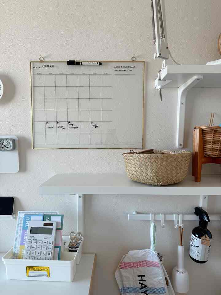白とナチュラルカラーのワークスペース、整理された収納アイデアと月間カレンダーが配置された印象的な空間