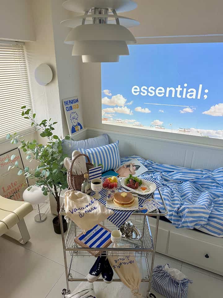 白と青のトーンが調和した寝室、ベッドとモジュールトロリーが配置された雰囲気のあるインテリア