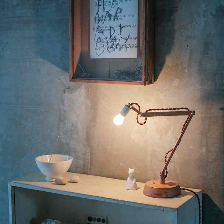 Natural brown wood tone table lamp and white objet on a rustic, natural ambience space