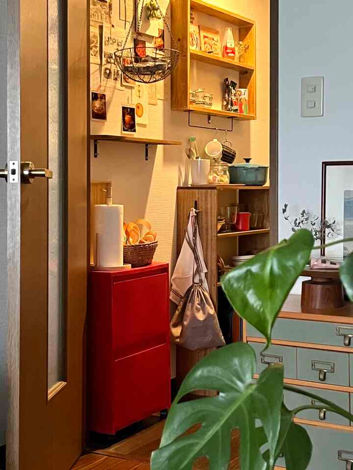赤い収納キャビネットと木目調の棚が配置された雰囲気のあるキッチンスペース
