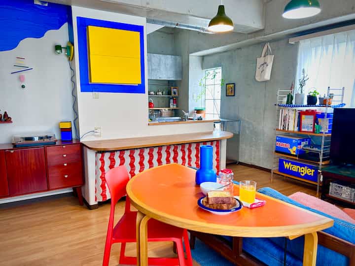 Nordic dining room with dominant red and yellow accents, natural wood floor, and colorful decor creating a cozy atmosphere