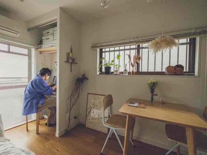 Beige and natural toned small room featuring plants and blinds with a cozy home office area