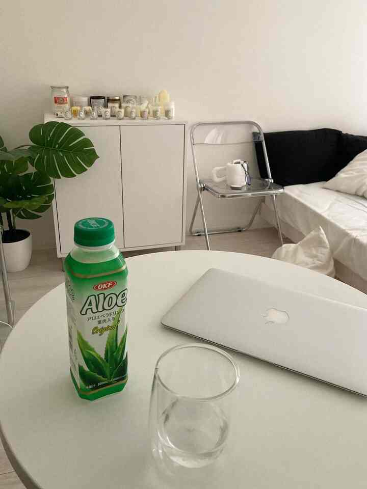 White-toned 1K 8-tatami studio room featuring a round table with drink and laptop, simple and natural interior