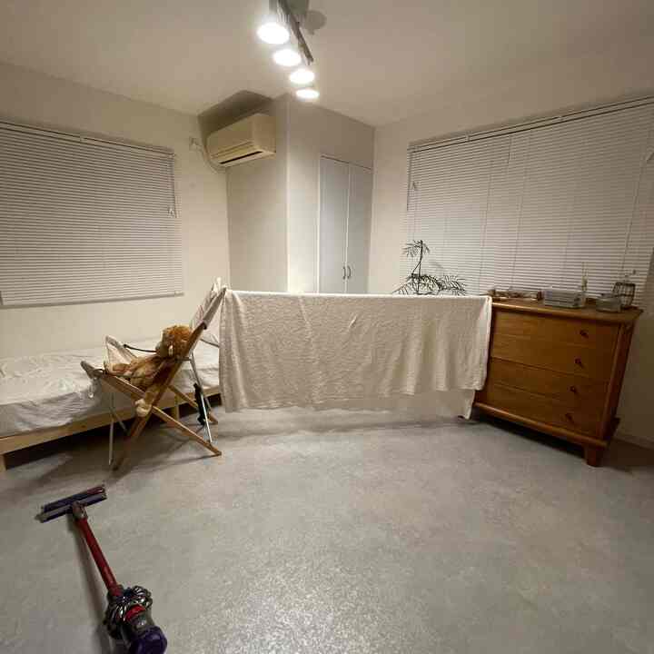 白と木目調の寝室、ビルトインクローゼットとベッド、大きなタオルが掛けられた実用的な空間