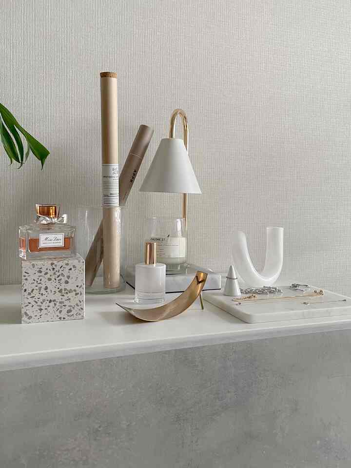 白とゴールドのトーンのテーブルにお香立てや装飾品が整然と配置されたミニマルなインテリア小物空間
