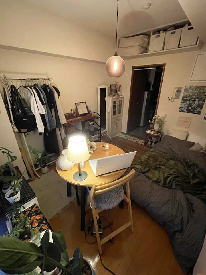 ナチュラルな木目調の小さな一人暮らしの寝室、テーブルランプとペンダントライトがある雰囲気のあるインテリア