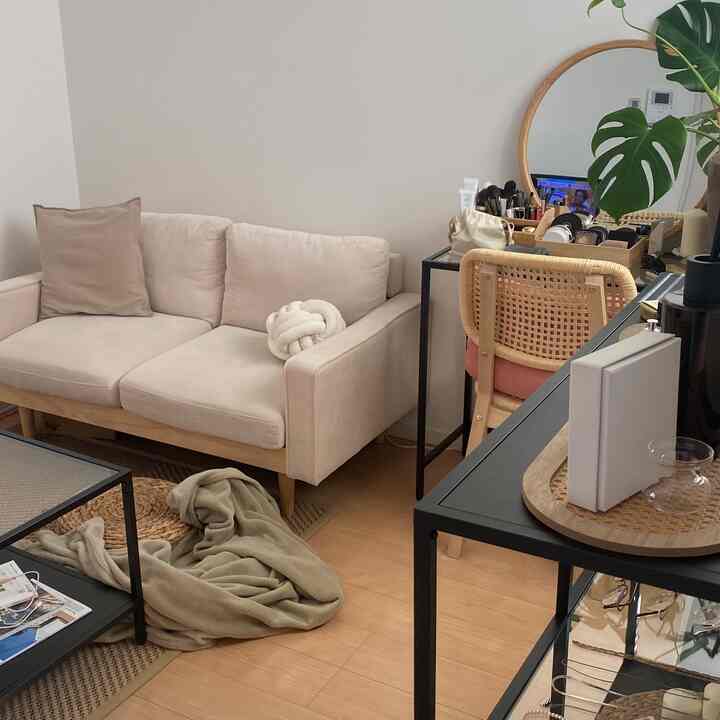 Natural-style living room with beige and wood tones featuring a sofa and vanity in a clean, minimal setting