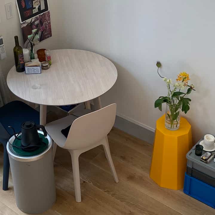 木目調の床と白い壁のダイニングルーム、丸いダイニングテーブルと椅子が配置された印象的な空間