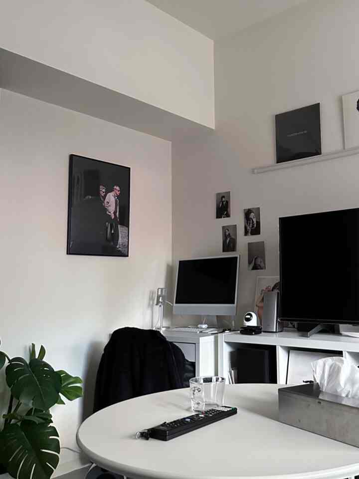 白を基調としたダイニングルーム、中央に丸いテーブルとコンピュータデスクが配置されたシンプルで清潔感のある空間