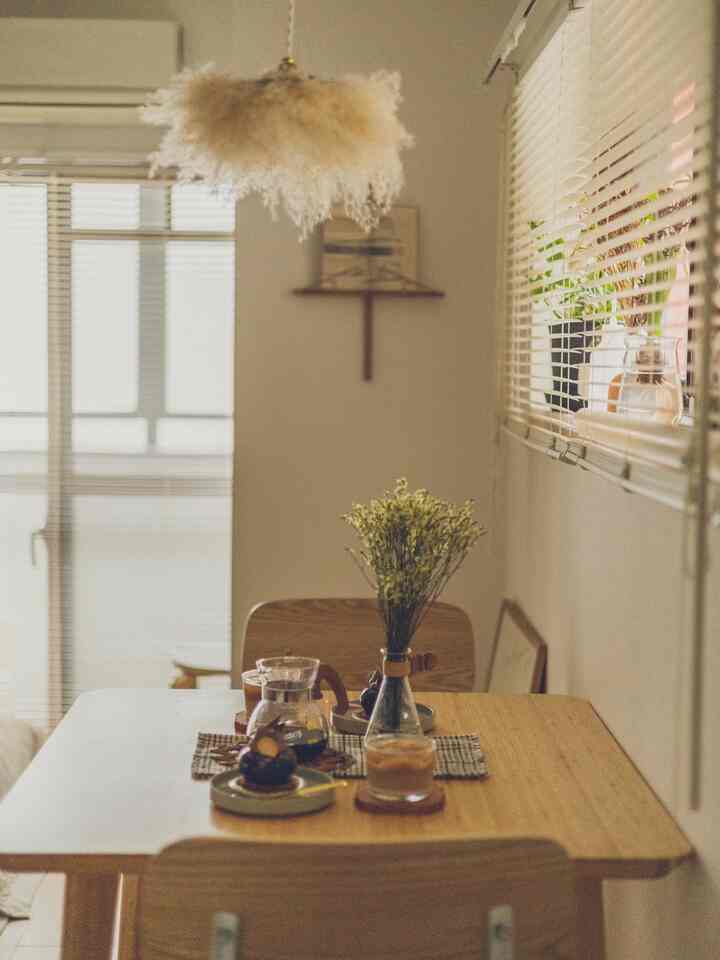 ベージュと木目調のダイニングルーム、中央の花瓶とコーヒーセットが温かみのあるおうちカフェの雰囲気を演出しているインテリア