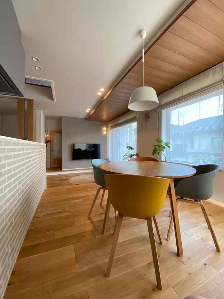 ナチュラルウッドトーンと大きな窓が印象的な、4人掛けのダイニングとリビングが一体となった居心地の良い空間