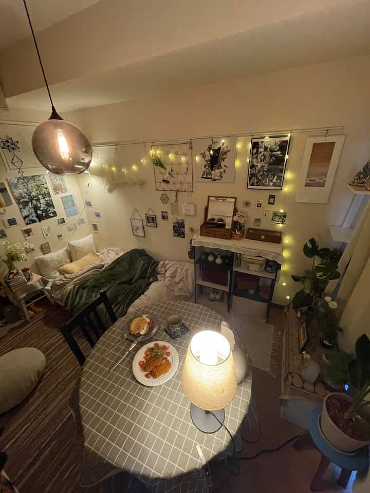 ナチュラルカラーの寝室、ベッドとテーブルランプ、フェアリーライトが配置され、温かみのある雰囲気のあるインテリア