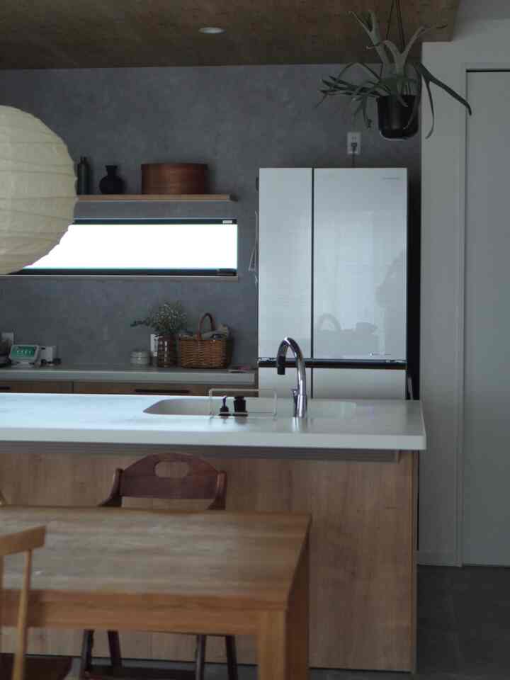 ナチュラルトーンと木製家具が配置されたダイニングとキッチン、落ち着いたシンプルな雰囲気のインテリア