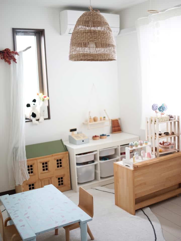 白と木目調が調和する北欧風の子供部屋、かわいいおもちゃと収納が配置された明るくて温かみのあるインテリア