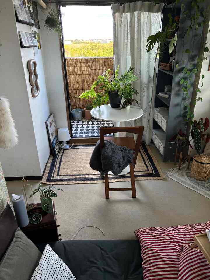 Natural toned compact living room featuring a round table with plants and a wooden chair in a cozy space