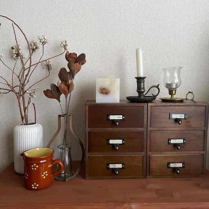 Brown-toned antique style drawer set with candles in a cozy decorative interior space