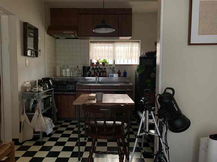 Black and white checkered floor with natural wood tones in a cozy small kitchen dining area featuring coffee equipment for a home cafe vibe