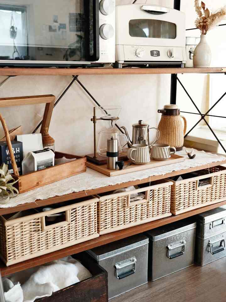 ナチュラルなブラウン色調の棚にコーヒー器具と多様な収納バスケットが整然と配置されたおうちカフェの空間