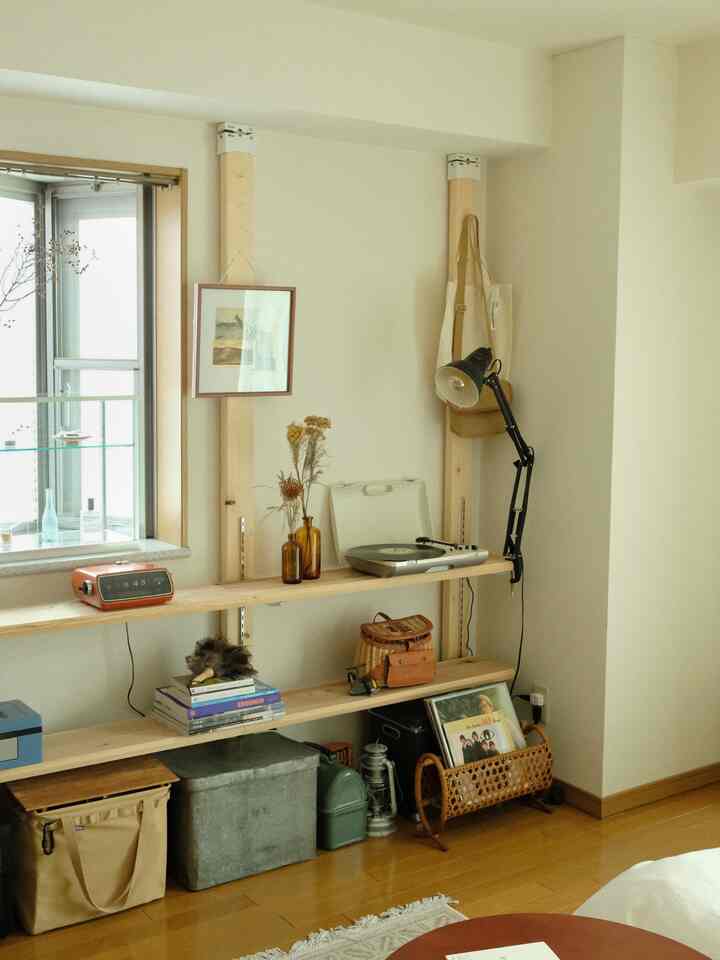 ナチュラルな木目調と白い壁が調和したリビングの一角、レトロな小物や本、レコードプレーヤーが配置された雰囲気のある空間