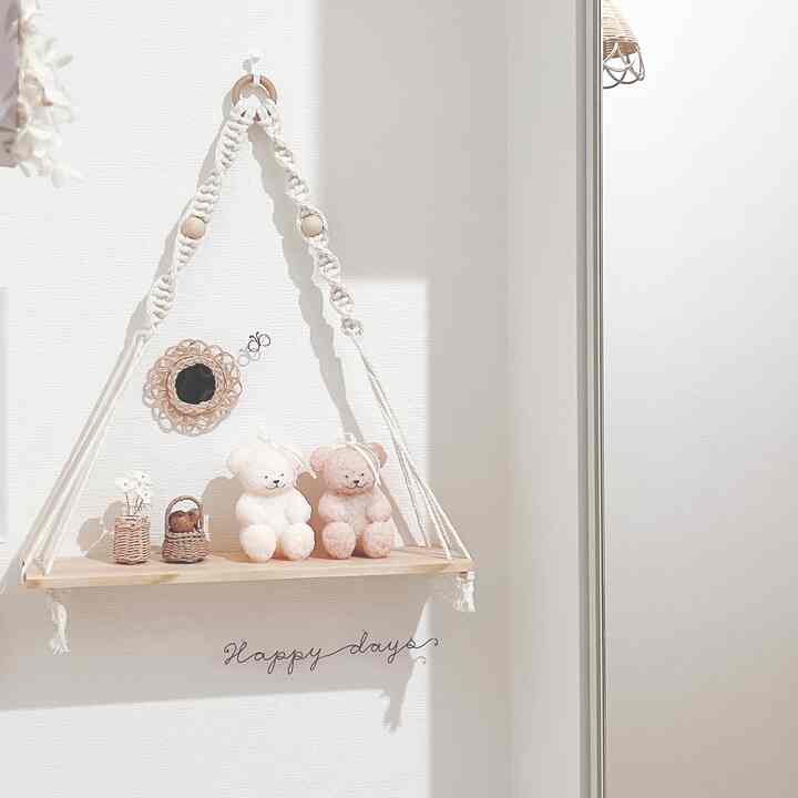 Natural color and white-toned bathroom featuring a hanging macrame shelf with teddy bears and simple decor elements