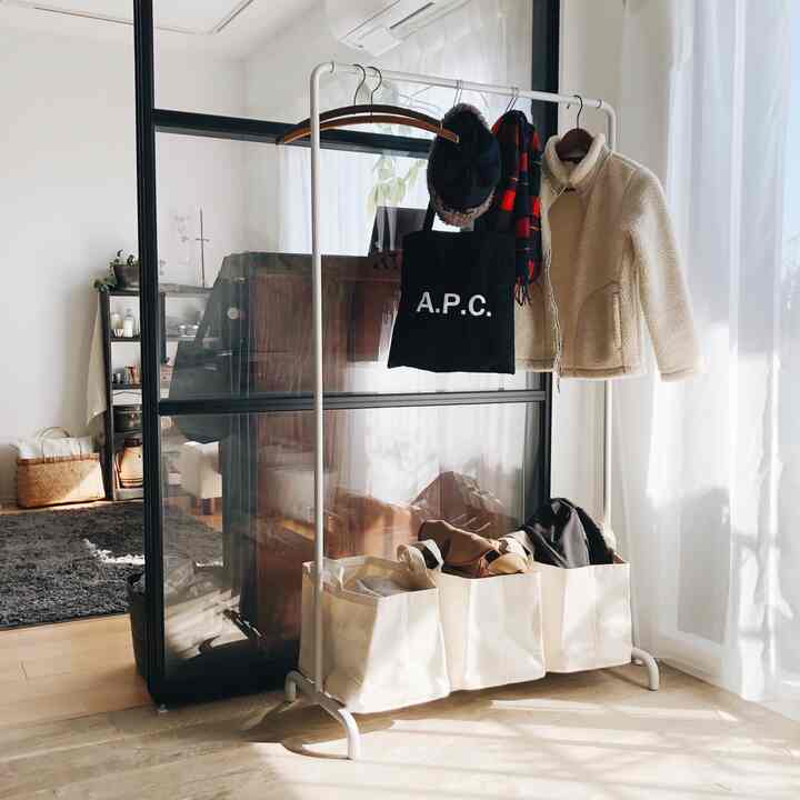 Bright living room in white and brown tones featuring MUJI steel hanger rack and storage baskets in a natural setting