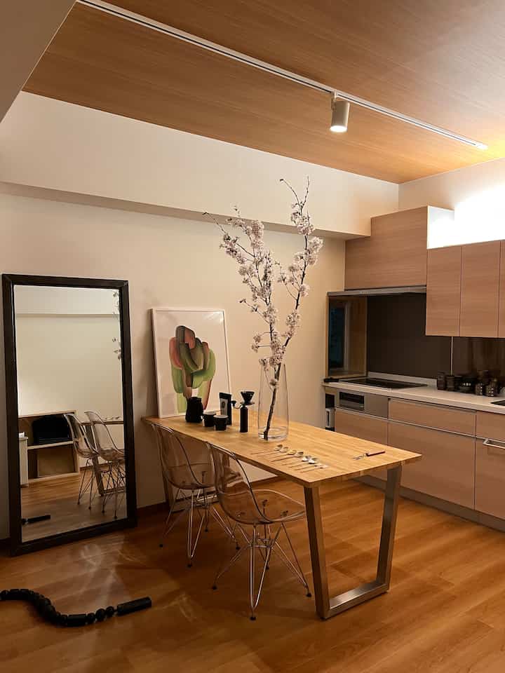 Warm wood tone and beige kitchen and dining room with large vase and mirror creating a cozy atmosphere