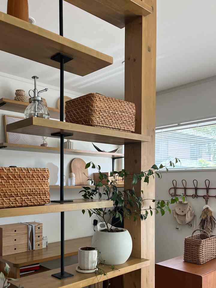 Natural brown-toned living space with shelves, rattan baskets, and indoor plants creating a cozy atmosphere