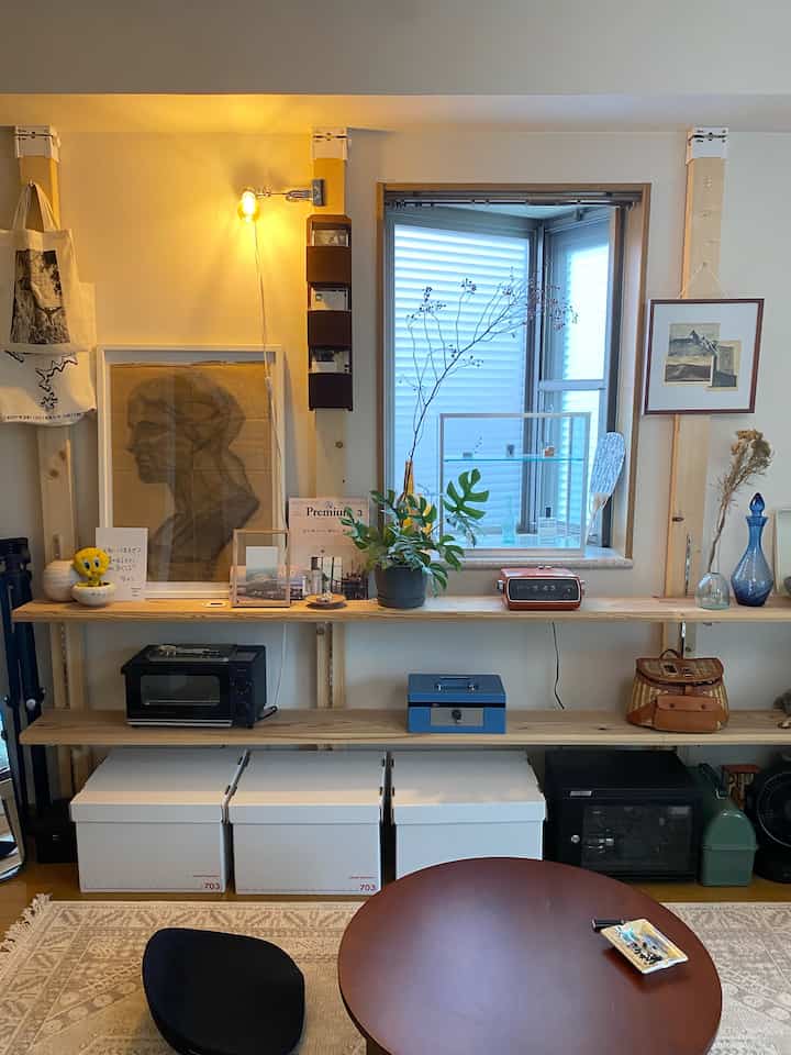 温かみのあるナチュラルカラーのリビング、木製テーブルと植物が配置された雰囲気のある空間