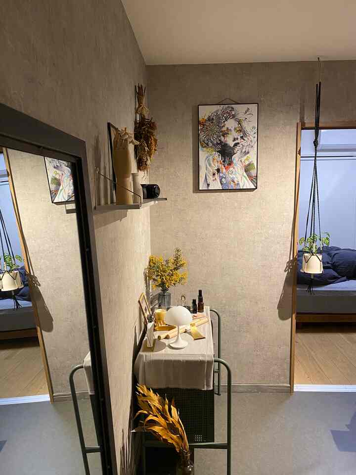 Natural color entrance space featuring wall art, small shelf with decor, and a mirror, creating a cozy atmosphere