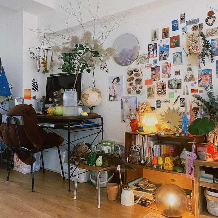 Brown and gold toned studio apartment featuring a desk and bookshelf in a cozy natural style space
