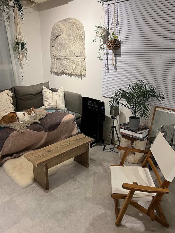 Natural color and white tone living room featuring sofa, bench, and plants creating a cozy atmosphere