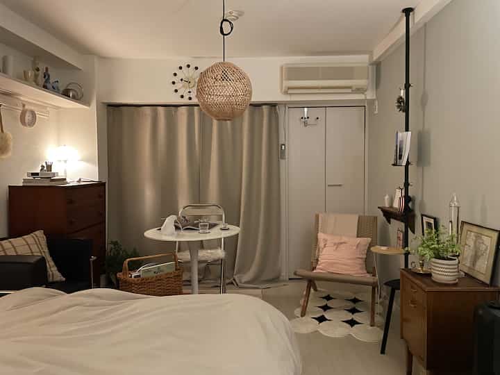 Cozy single household bedroom and small living area featuring natural wood tones and rattan lighting