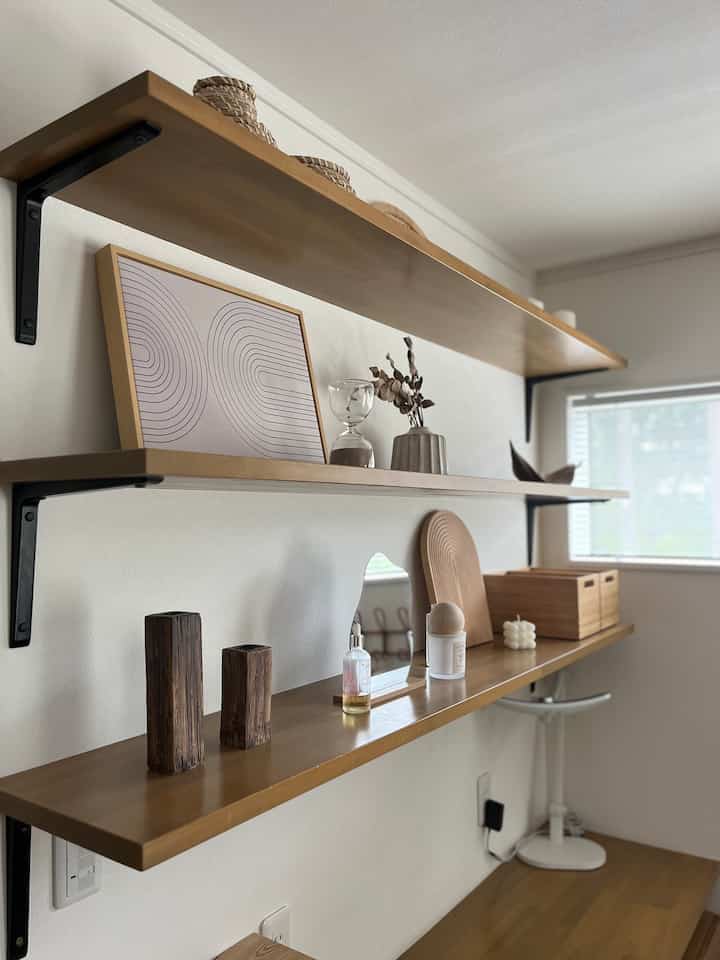 木目調とベージュ色の壁に取り付けられた棚が配置された、洗練されたインテリアのディスプレイ空間