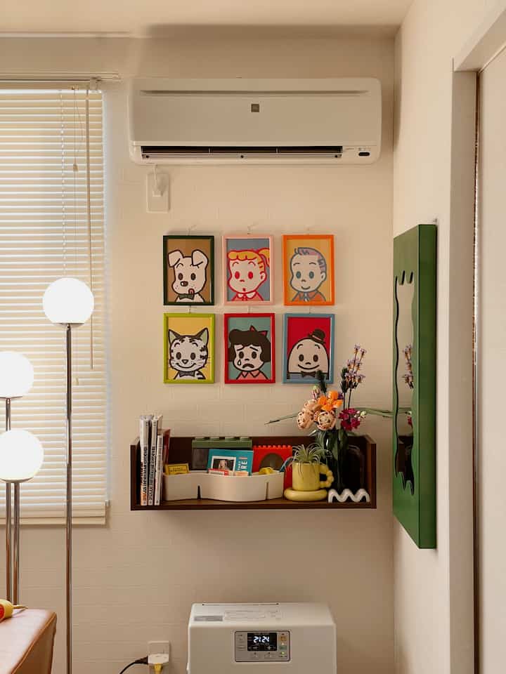 白い壁と木目調の棚があるミッドセンチュリーモダンなリビング、レトロなアートとフロアランプが配置された印象的な空間