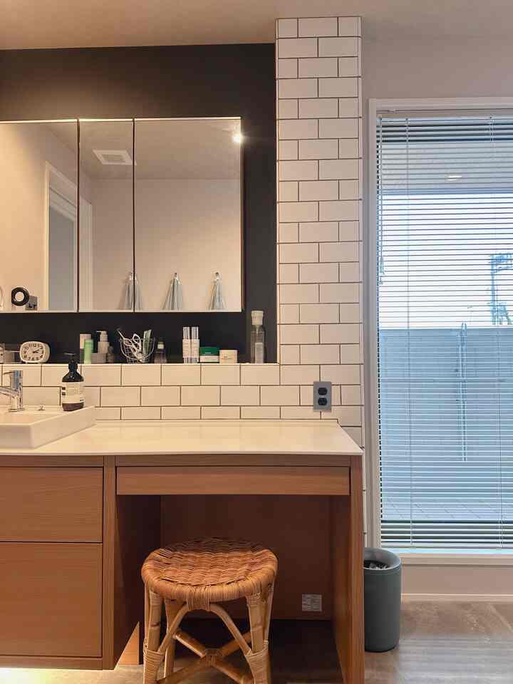 White and wood tone hotel-like powder room featuring a stylish stool and clean lighting for a refined atmosphere