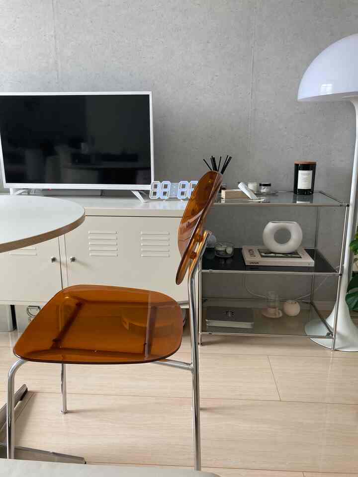 モダンで透明なブラウン色のダイニング、清潔感のある家具とテレビが配置された雰囲気のあるインテリア