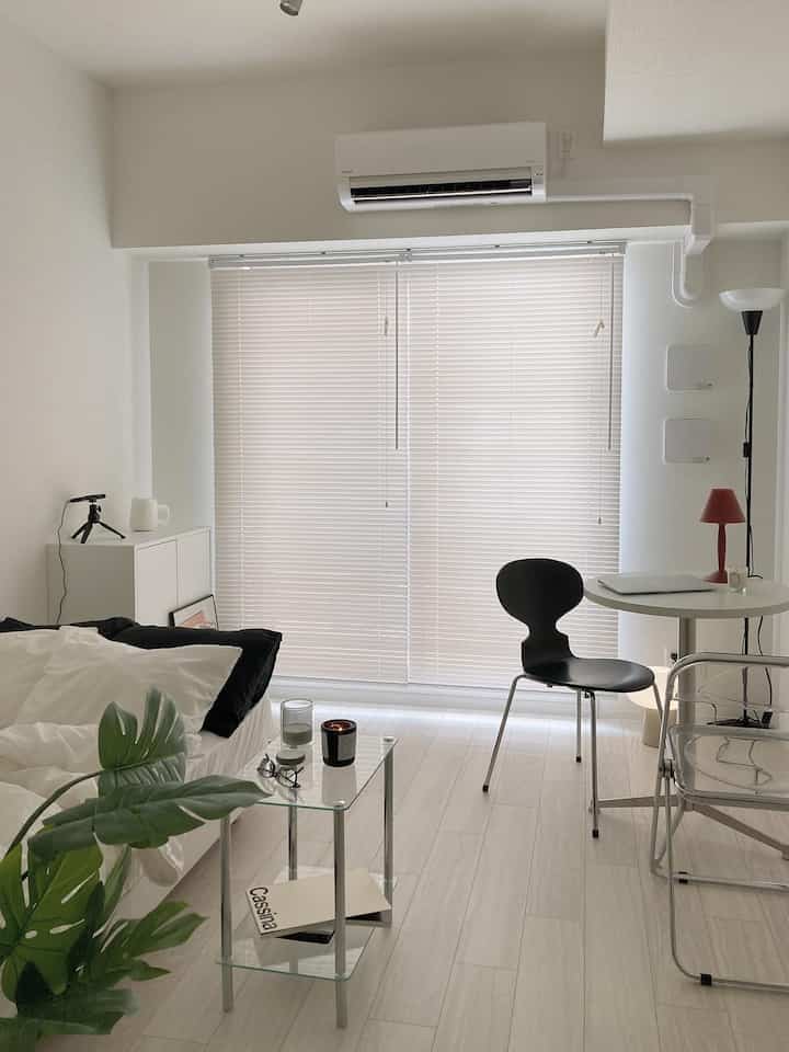 Modern living room in white and black tones featuring a sofa bed and side table with a clean, calm atmosphere