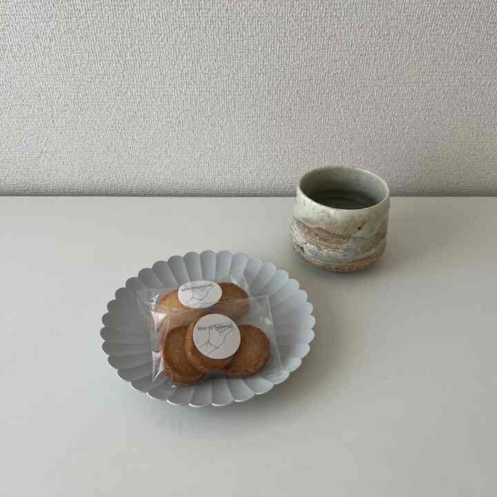 Simple studio apartment with white background featuring a gray plate and ceramic cup centrally placed for cozy home cafe time