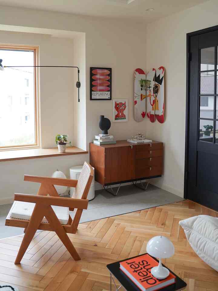 Natural living room with white walls and brown wood-tone furniture, featuring an armchair and side table arranged harmoniously