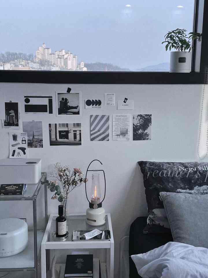Modern and calm bedroom in white and black tones featuring a nightstand and mood light