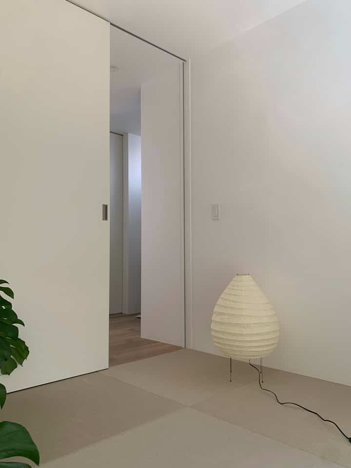 Natural beige and white-tone tatami room featuring a Wa-Modern style floor lamp blending tradition and modernity in a simple setting