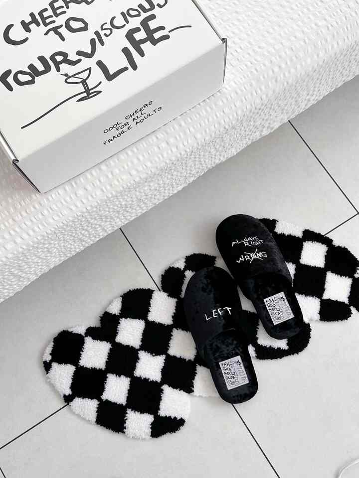 Minimal space with black slippers on a black-and-white checkered rug over white tiled floor