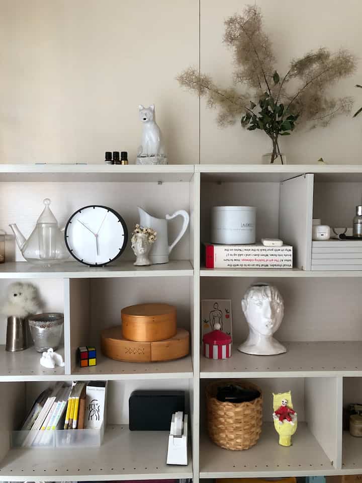 White and natural tone shelf in a living room featuring objet decor, creating a clean and modern atmosphere