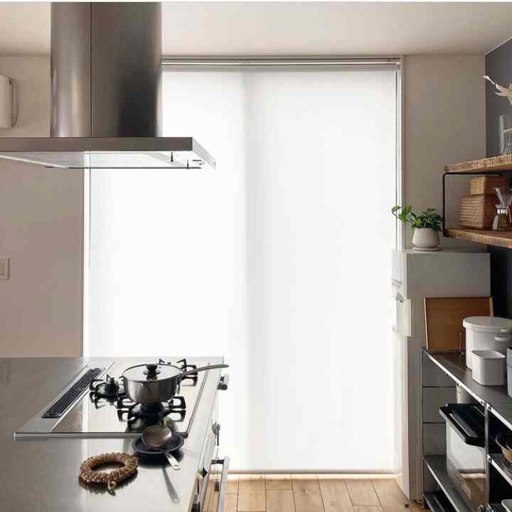 白とナチュラルウッドトーンが調和したシンプルなキッチン、ステンレス製ガスコンロと収納棚が配置された雰囲気のあるインテリア